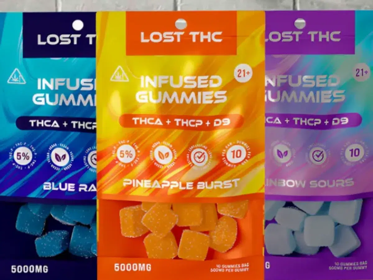 Packaging for "LOST THC Infused Gummies" in blue raspberry, pineapple burst, and rainbow sours flavors. THCA gummies